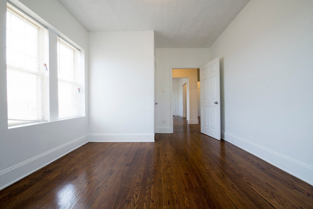 an empty living room with white walls and wood floors