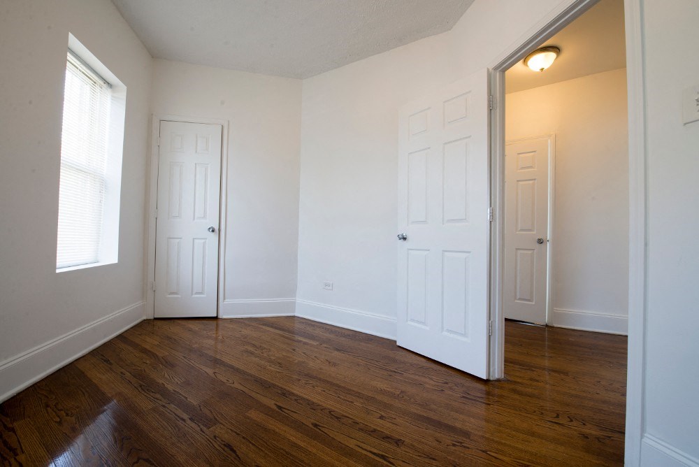 an empty living room with white walls and wood floors