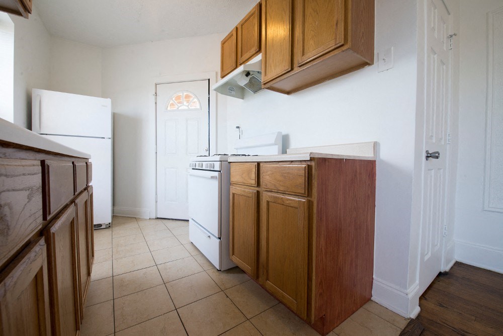a kitchen with wooden cabinets and a white refrigerator and a sink