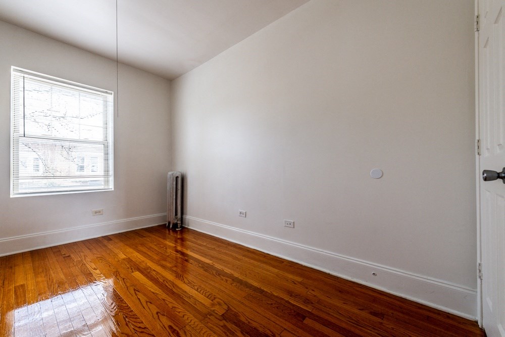 an empty room with wooden floors and a window