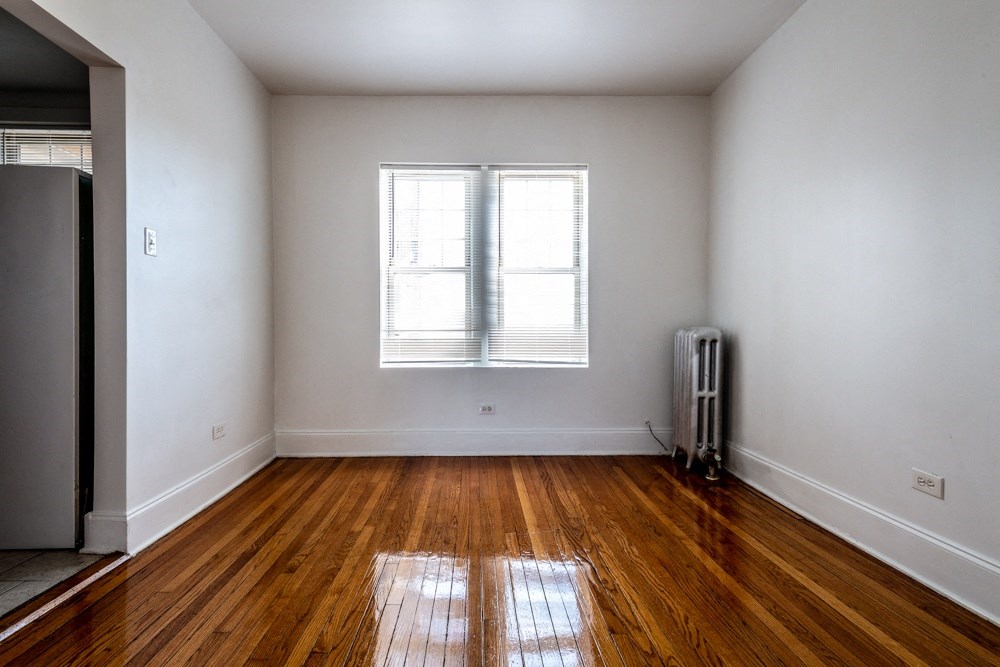 an empty room with wooden floors and a window