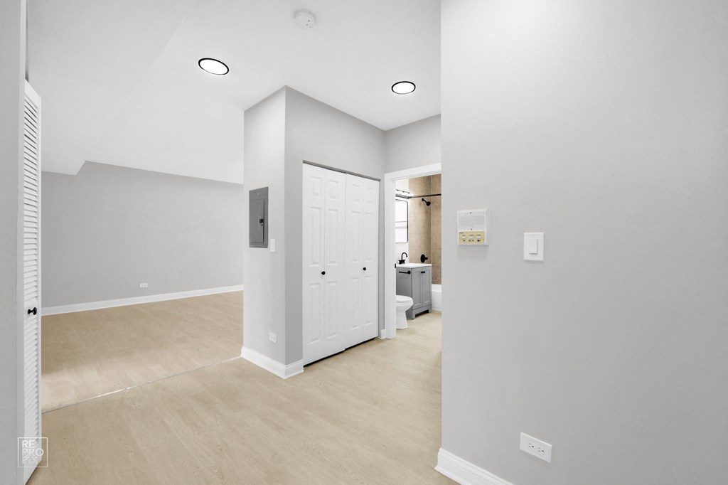 a bedroom with a medium sized bed and a doorway into a bathroom with a sink and toilet