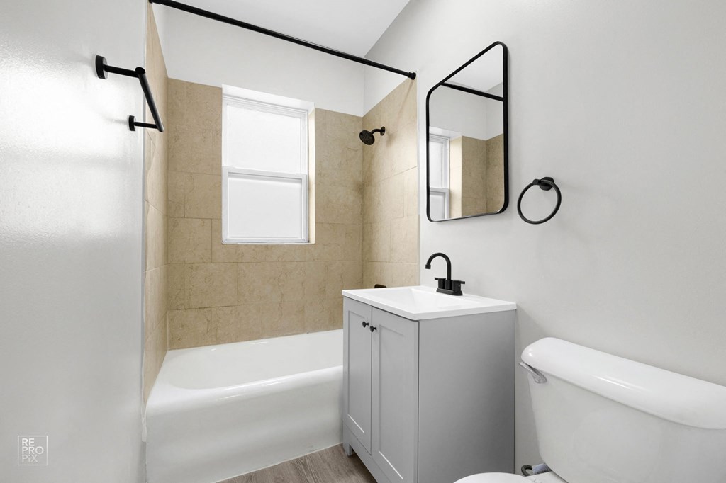 a bathroom with white walls and a beige tiled floor