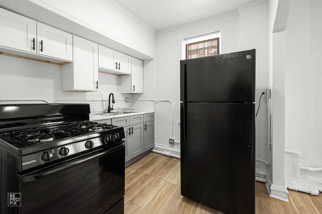 a kitchen with black appliances and white cabinets