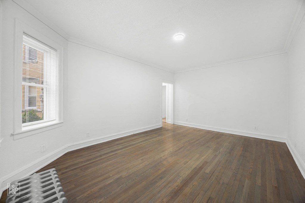 an empty living room with white walls and wood floors