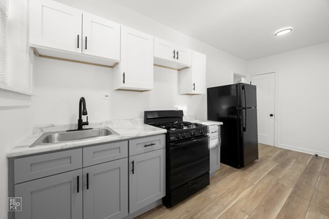 a renovated kitchen with white cabinets and black appliances