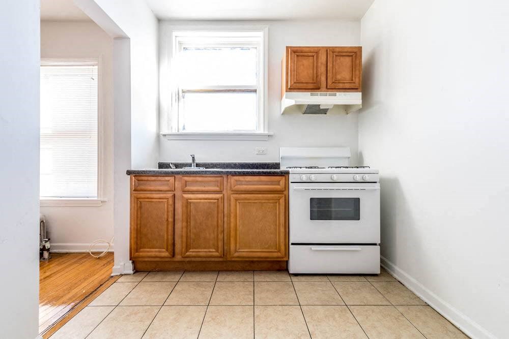 a kitchen with a stove and a sink and a window