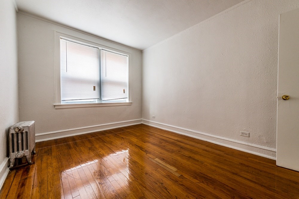 the living room of a house with wooden floors and a window