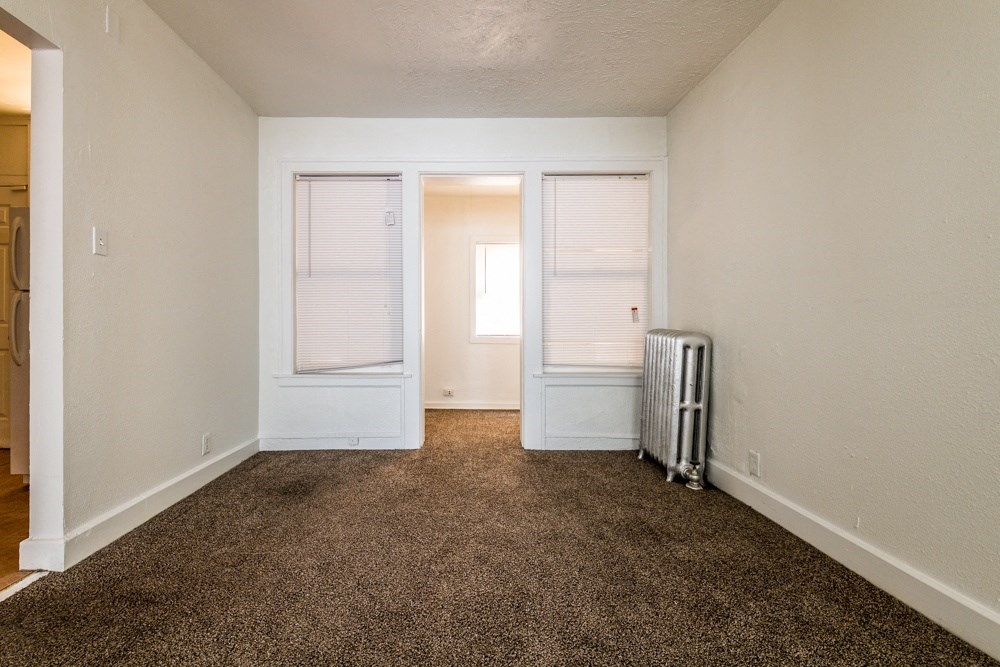 an empty room with a carpeted floor and white walls