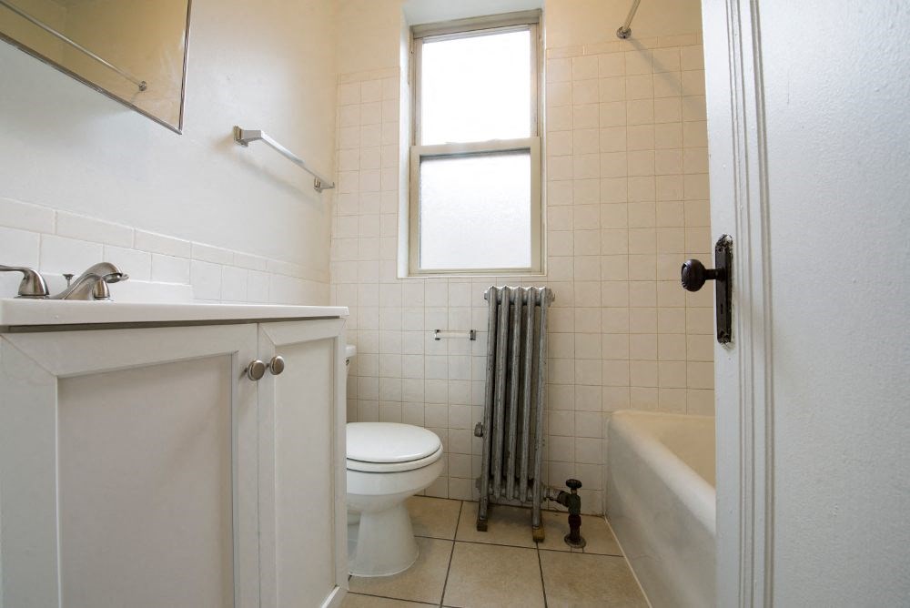 a bathroom with a toilet and a tub and a sink