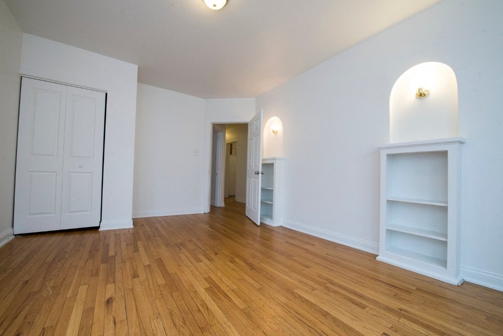 an empty living room with white walls and wood floors
