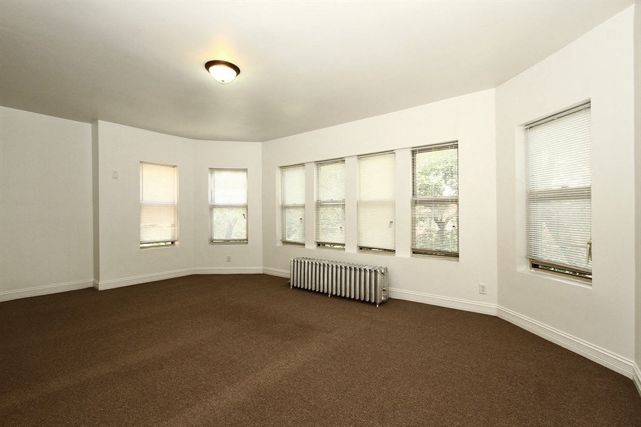 an empty living room with a heater in the corner