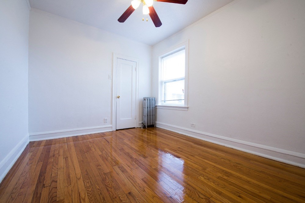 the living room of an empty house with wood floors and a window