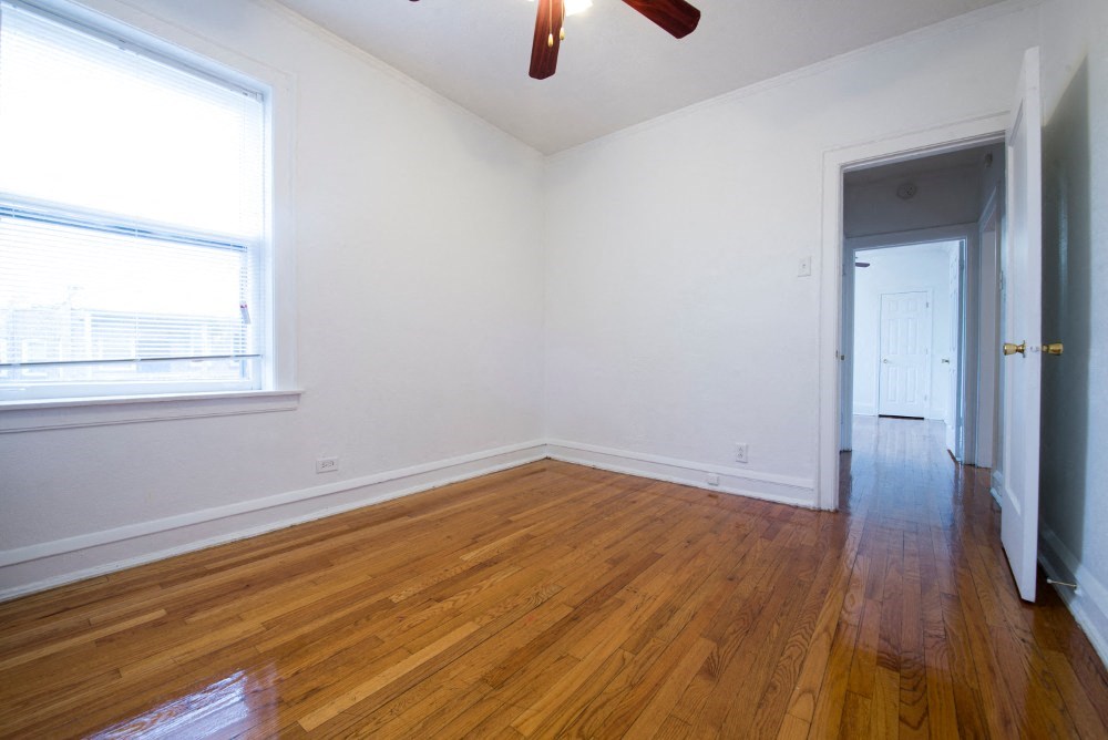 an empty room with wooden floors and a window