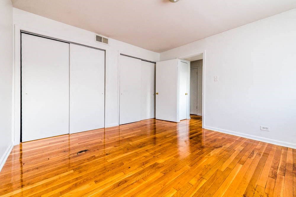 an empty room with wooden floors and white walls