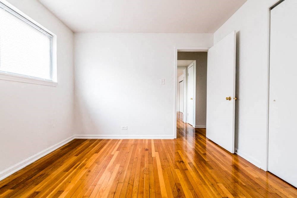 an empty room with wooden floors and white walls