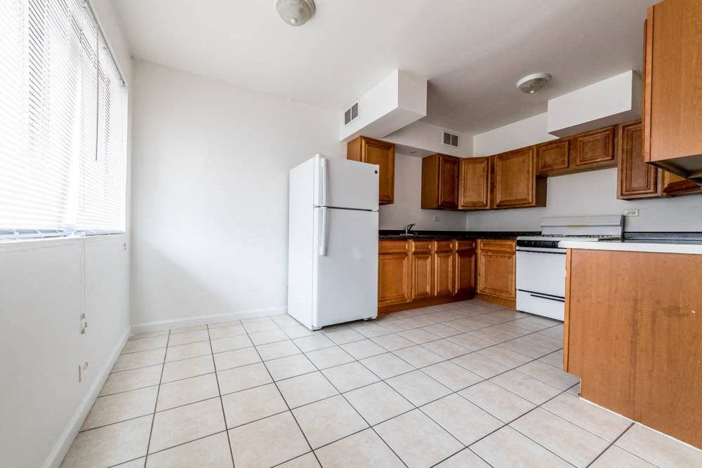 an empty kitchen with a refrigerator and a stove