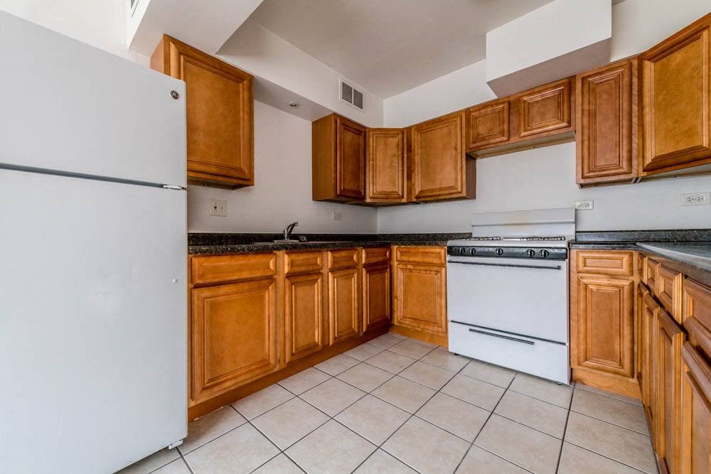 a kitchen with white appliances and wooden cabinets