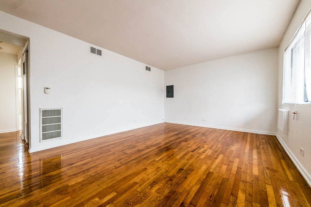 an empty room with a hard wood floor and white walls