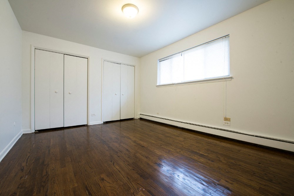 the living room of an empty house with wood floors and a window