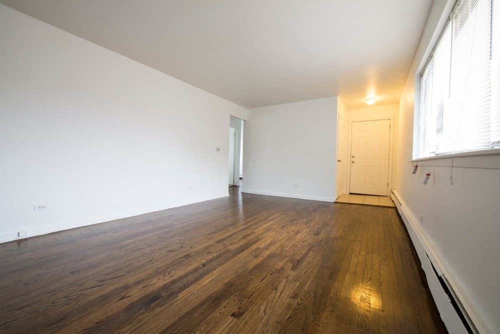 an empty living room with white walls and wood floors