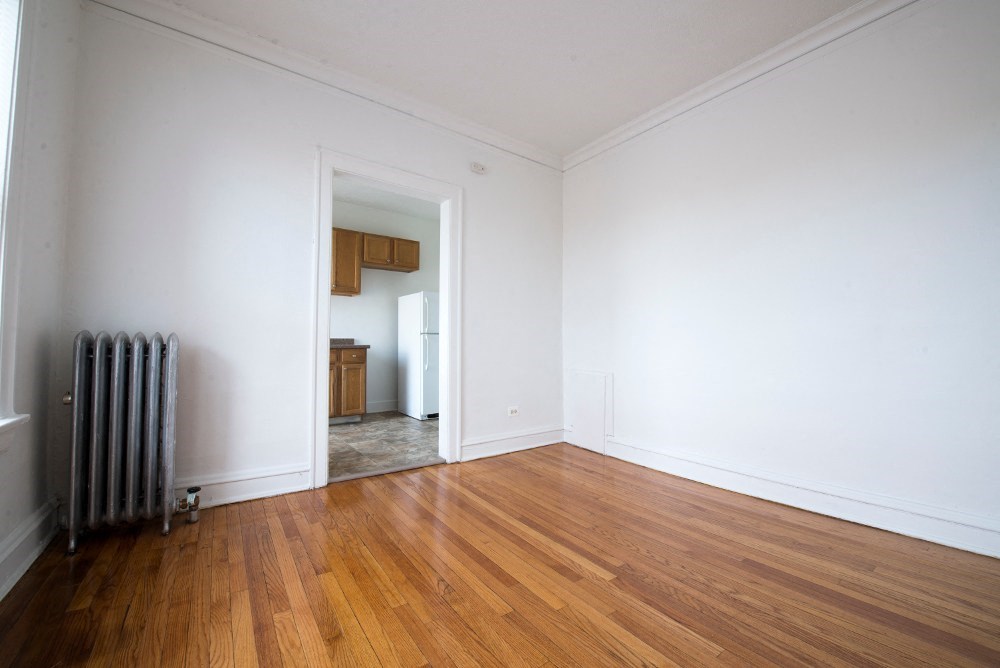 an empty living room with white walls and wood floors