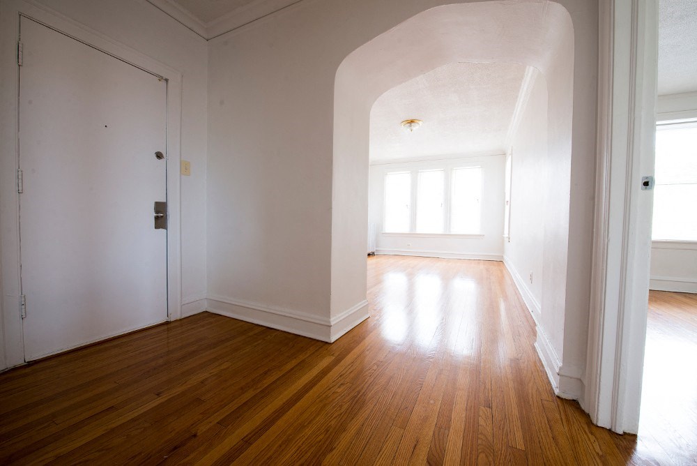 an empty living room with white walls and wooden floors