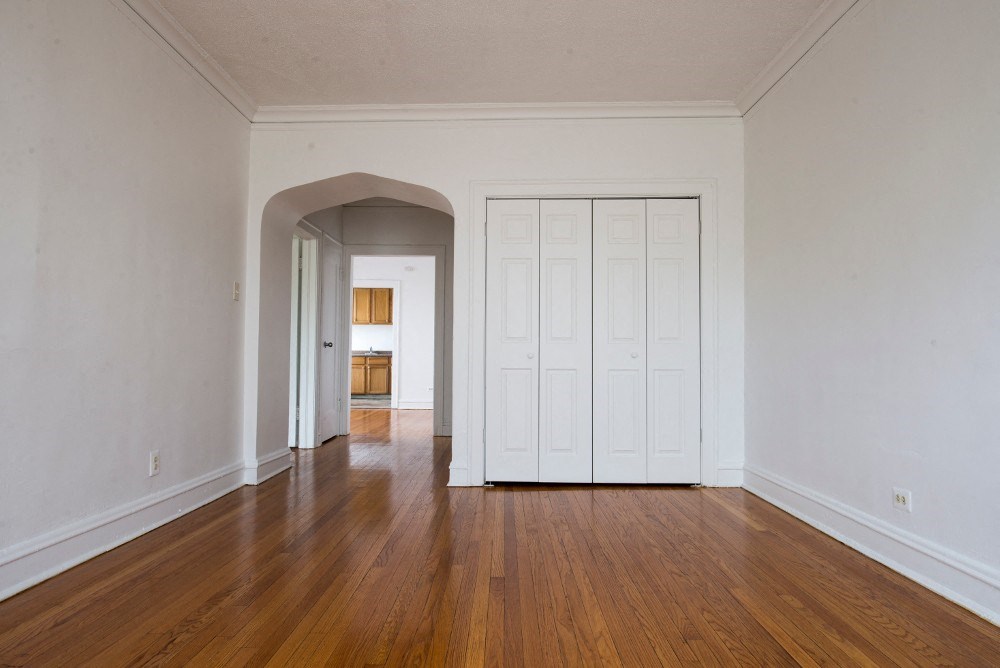 an empty living room with white walls and wood floors