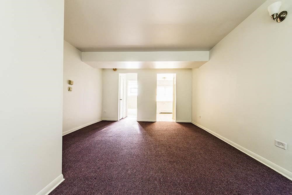 an empty room with a carpeted floor and white walls