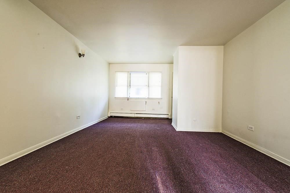 an empty room with carpet and a window