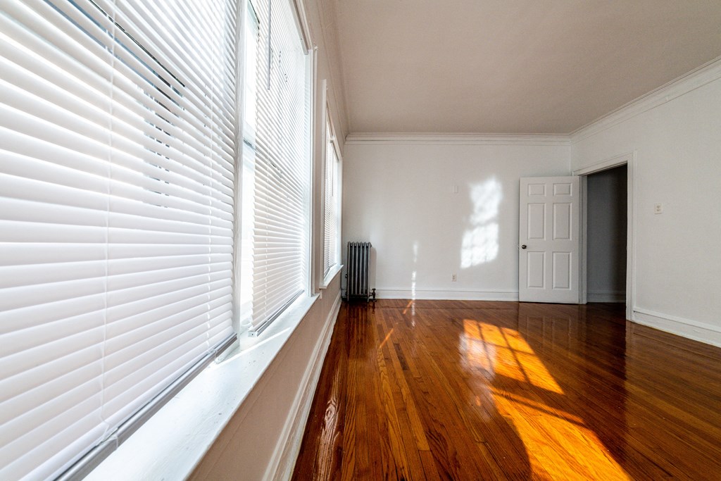 a living room with white walls and wood floors and a white door