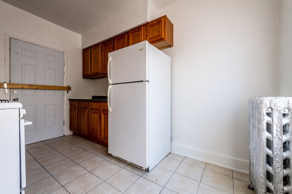 a kitchen with a white refrigerator and wooden cabinets