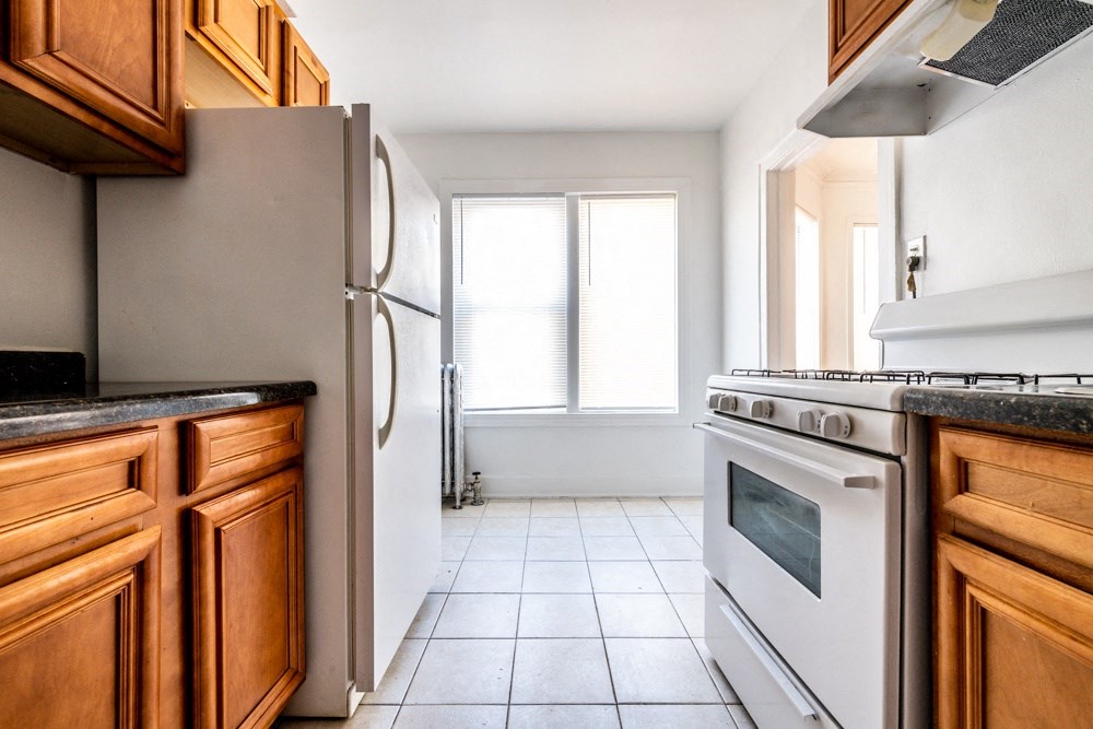 a kitchen with white appliances and wooden cabinets