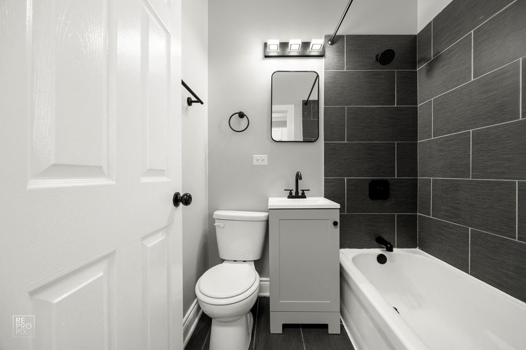 a black and white bathroom with a toilet sink and tub