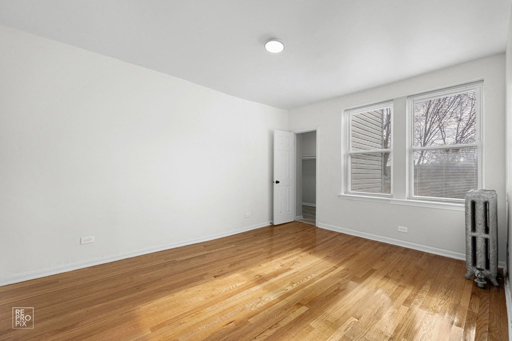 a living room with hardwood floors and a large window