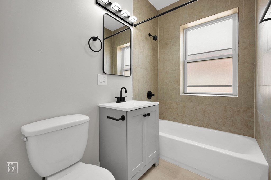 a bathroom with a toilet sink and bathtub in a 555 waverly unit