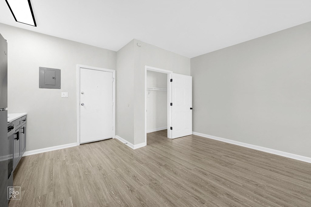 a bedroom with hardwood floors and grey walls