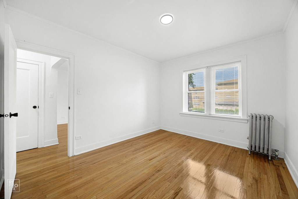 a living room with white walls and wood floors