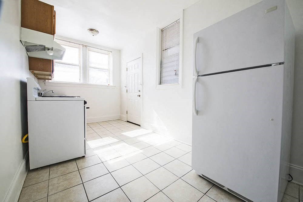 an empty kitchen with a refrigerator and a sink