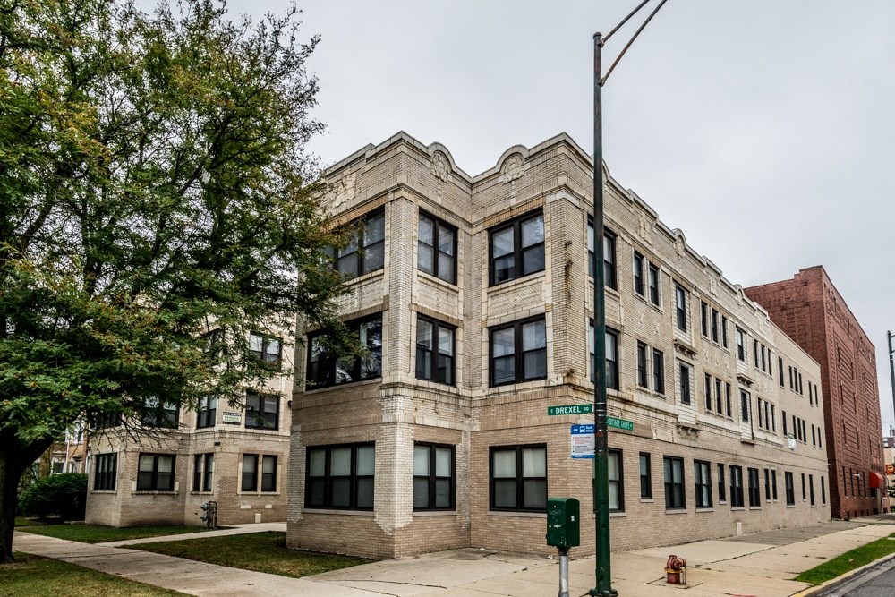 a brick building with large windows and a tree in front of it