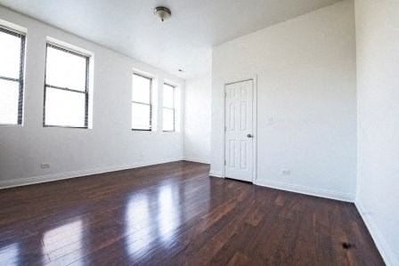 an empty living room with white walls and wood floors