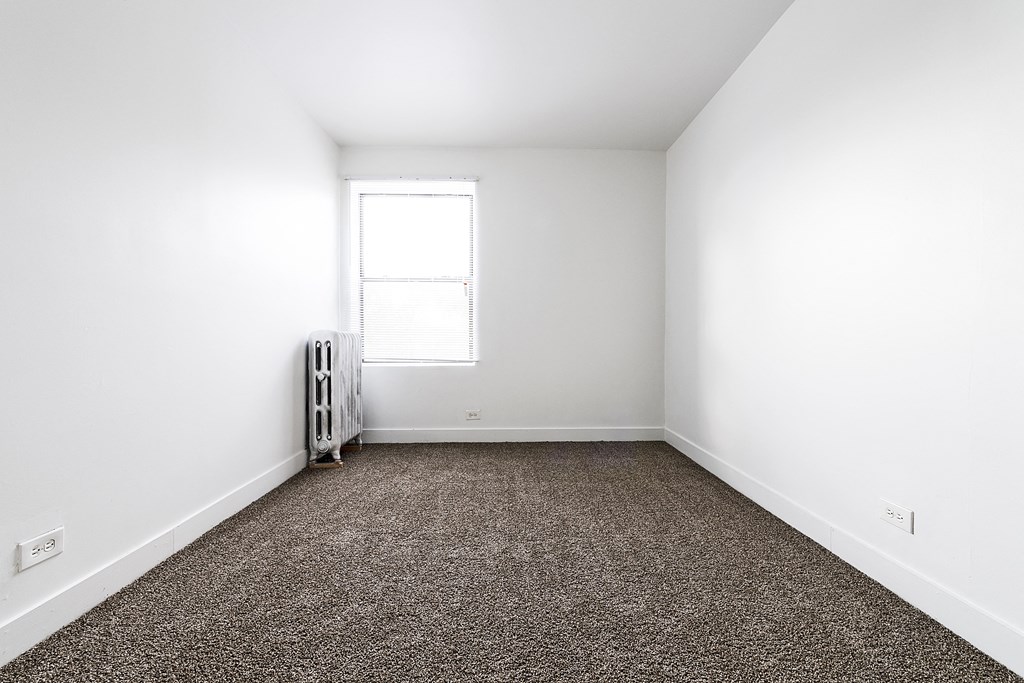 an empty room with carpet and a window