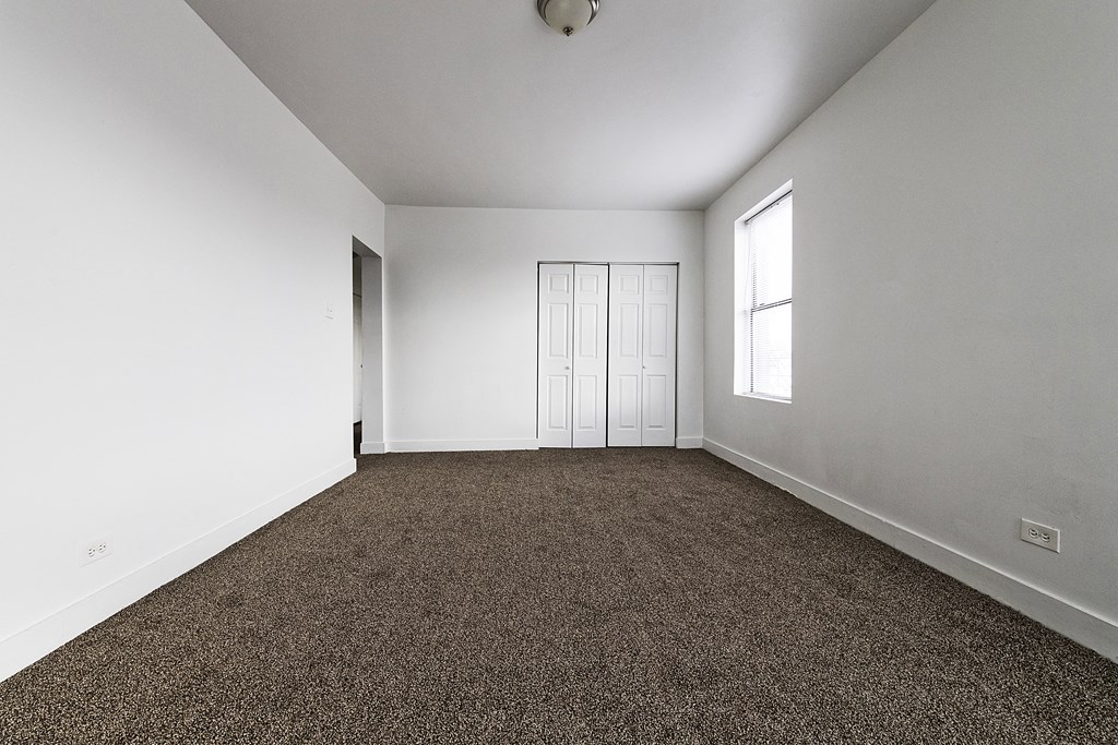 an empty room with carpeting and a window