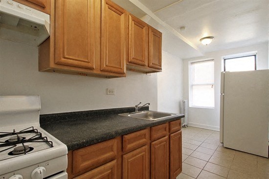 a kitchen with a stove and a sink and a refrigerator