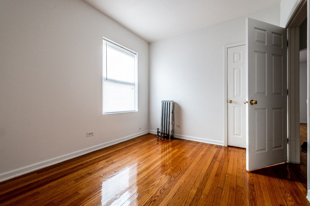 an empty room with wooden floors and a white door
