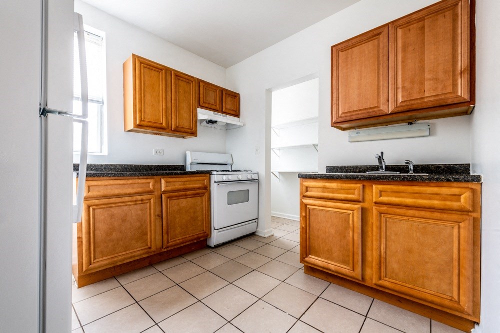 the kitchen is clean and ready to use with wood cabinets and white appliances