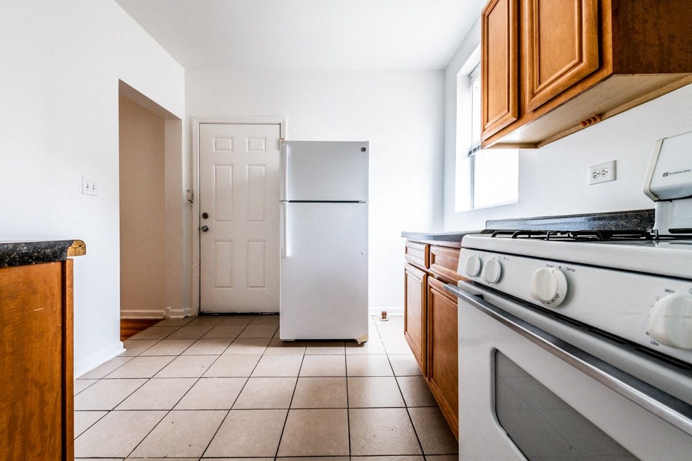 a kitchen with white appliances and a refrigerator