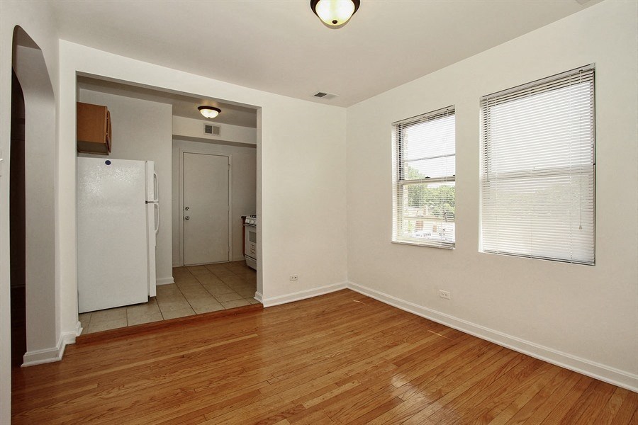 the living room and kitchen of an empty house with wood floors