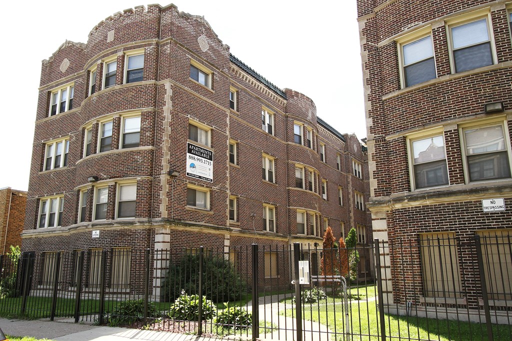 a large brick building with a fence in front of it