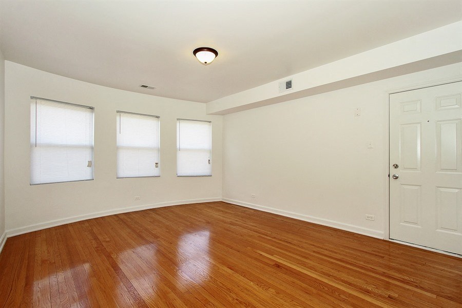 an empty living room with wood floors and a white door